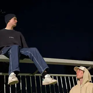 The duo talking on a balcony at night