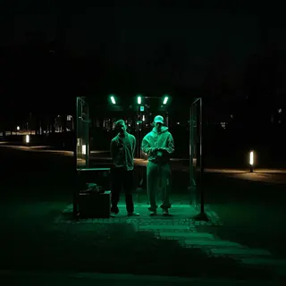 The duo beneath green lights at night