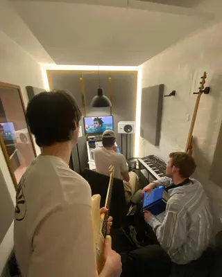 Friends gathered around the studio piano